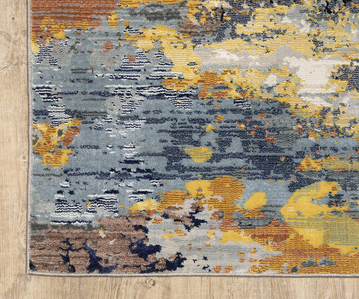 The Oriental Weavers Caravan / 530V Rug, showcased on a light wood floor, features abstract nature-inspired patterns in blue, yellow, orange, and cream tones. Crafted from space-dyed polyester for nuanced color variations, this piece from the Caravan Collection offers a textured design with artistic blends of color.
