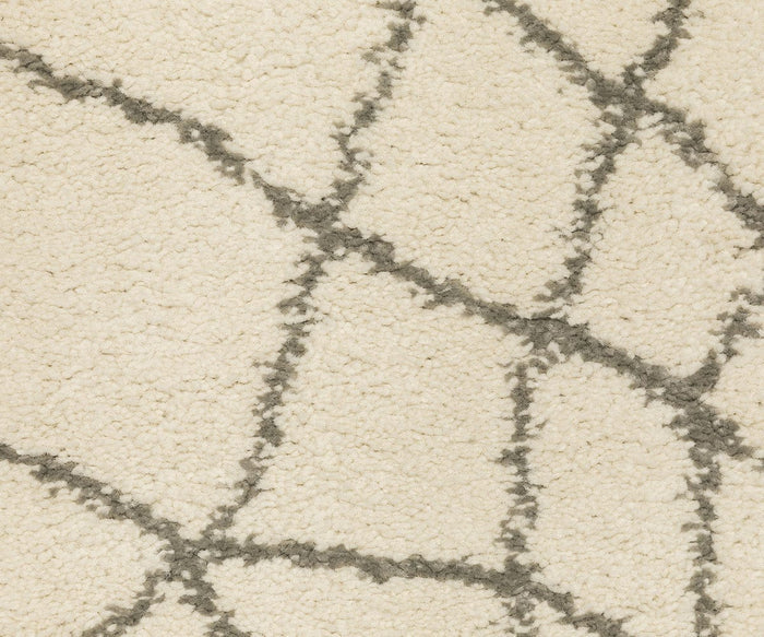 Close-up of the Oriental Weavers Carson / 738B Rug: a cream-colored, textured carpet with a plush feel, showcasing irregular dark gray lines intersecting to create an abstract geometric pattern—a contemporary and inviting rug crafted from durable polypropylene.
