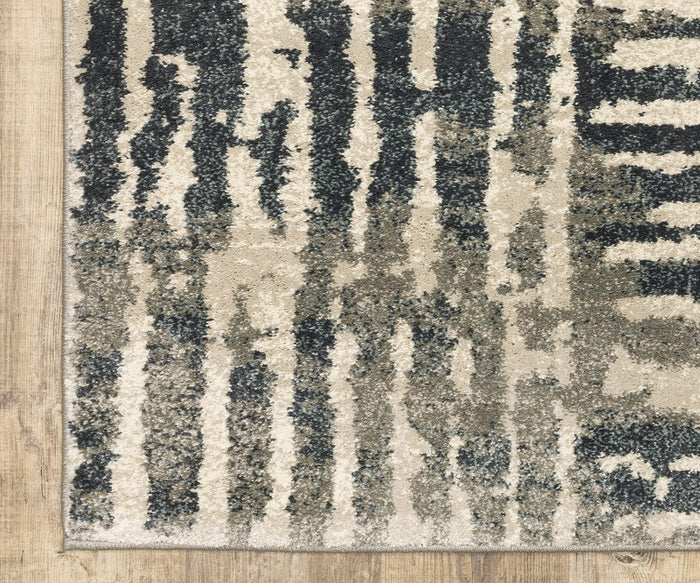 A corner of the Oriental Weavers Carson / 745C Rug from the Carson Collection, featuring plush texture and abstract vertical lines in beige, gray, and black tones, is shown on a wooden floor.
