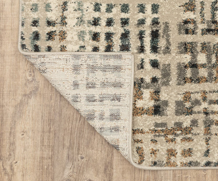 A close-up of the rectangular Oriental Weavers Carson / 748F Rug showcases its contemporary geometric pattern in beige, gray, and blue tones on a wooden floor. Crafted from durable polypropylene, one corner is folded back to reveal the underside.