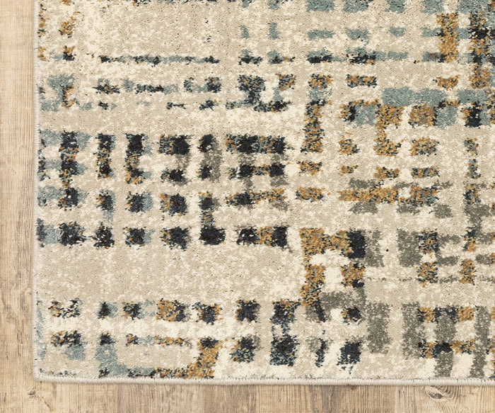 A close-up of the Oriental Weavers Carson / 748F Rug highlights its rectangular silhouette and abstract geometric design in beige, gray, blue, and mustard shades, crafted from durable polypropylene and laid on a light wood floor.