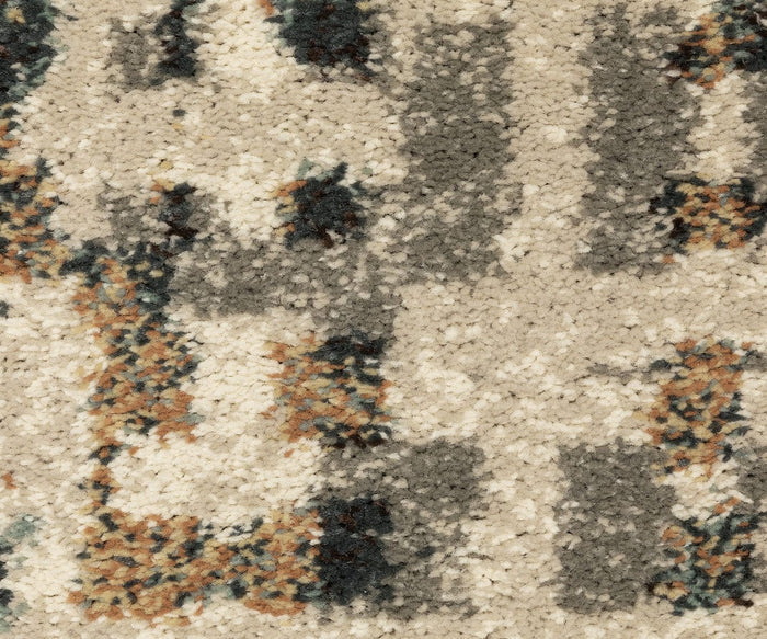 Close-up of the Oriental Weavers Carson / 748F Rug, featuring a plush area rug with a textured surface and an abstract geometric pattern in beige, gray, dark blue, and brown tones. Made from durable polypropylene fibers with varied coloration, this contemporary rug offers a soft and cozy appearance.