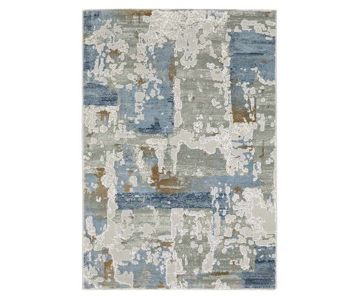 The Oriental Weavers Easton 4518X Rug is a rectangular area rug from the Easton Collection, showcasing an abstract multi-color pattern that blends blue, gray, white, and tan tones. Power-loomed for durability, this modern rug features a textured design reminiscent of weathered paint or contemporary art, making it both an artistic and practical addition to any living space.