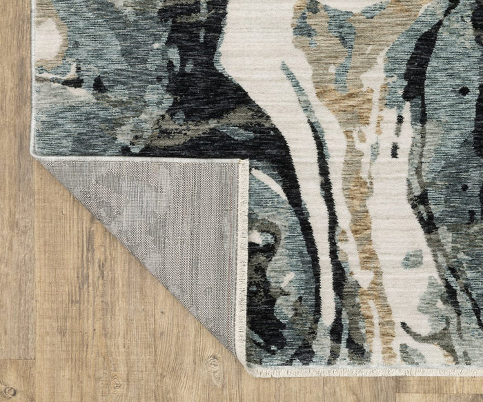 A corner of an Oriental Weavers Echo / ECH07 Rug, power-loomed in Egypt, is folded over on a wooden floor, revealing the rug’s textured gray underside and its abstract pattern of black, gray, blue, and beige on top.