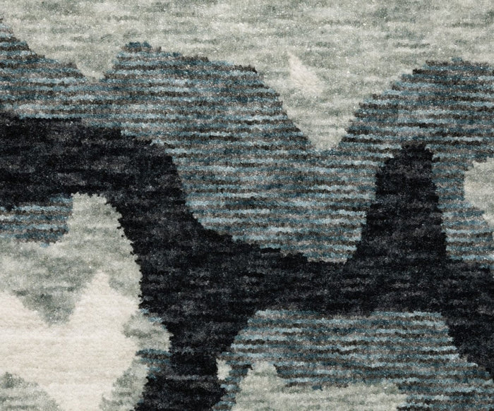 A close-up of the Oriental Weavers Echo / ECH08 Rug, power-loomed in Egypt, showcasing its textured surface with an abstract pattern of irregular shapes and horizontal lines in shades of gray, black, and white.