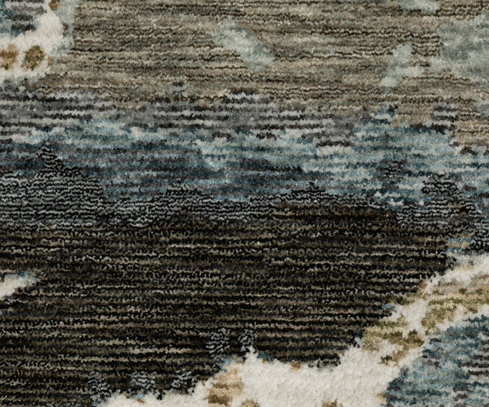 Close-up of a textured Oriental Weavers Echo ECH12 Rug, featuring abstract patterns in shades of blue, gray, black, and white that form an irregular, modern design. Power-loomed in Egypt for lasting style and quality.