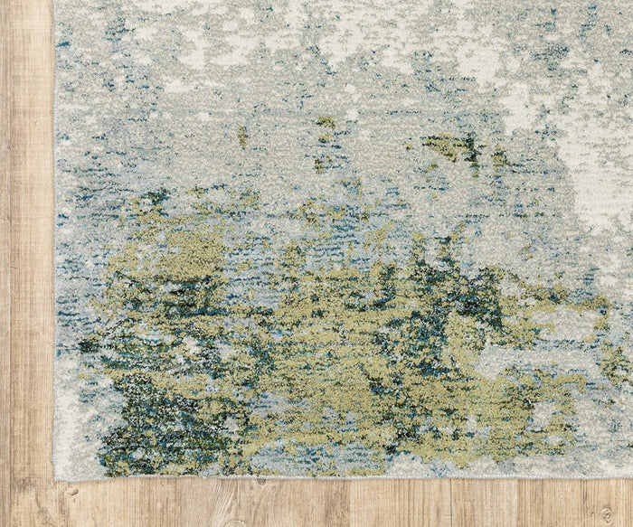 Corner of the Oriental Weavers Evolution / 8039E Rug, displaying abstract green, blue, and cream patterns over a light wooden floor. Crafted from durable nylon, this modern and organic design blends soft colors and shapes while remaining easy to maintain.