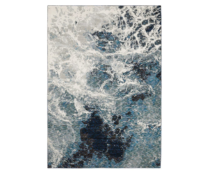 The Oriental Weavers Evolution / 962A Rug is a rectangular area rug from the Evolution Collection, showcasing an abstract design in blue and multi-colored tones reminiscent of ocean waves or swirling water. Made from durable nylon, this stylish rug is easy to maintain and offers both practicality and visual appeal for any space.