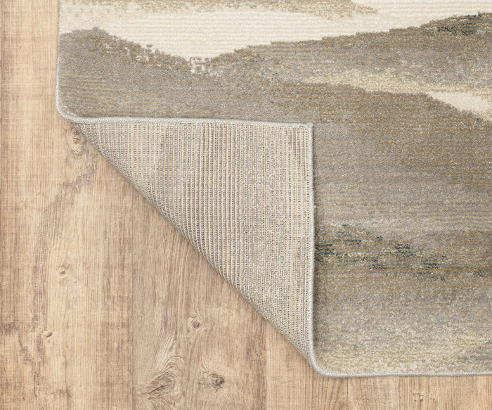 The Oriental Weavers Evolution / 982C Rug, shown here in beige and gray with one corner flipped to display its textured non-slip backing, rests atop a light brown wooden floor. Crafted from durable nylon for easy maintenance, this area rug is designed to offer long-lasting style.