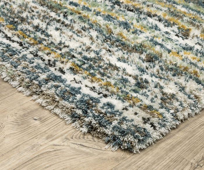 Close-up of the corner of an Oriental Weavers Galileo / GAL07 Rug, featuring blue, green, yellow, and white tones. Placed on a light wood floor, the rug’s dense pile and thick, textured fibers are clearly visible.