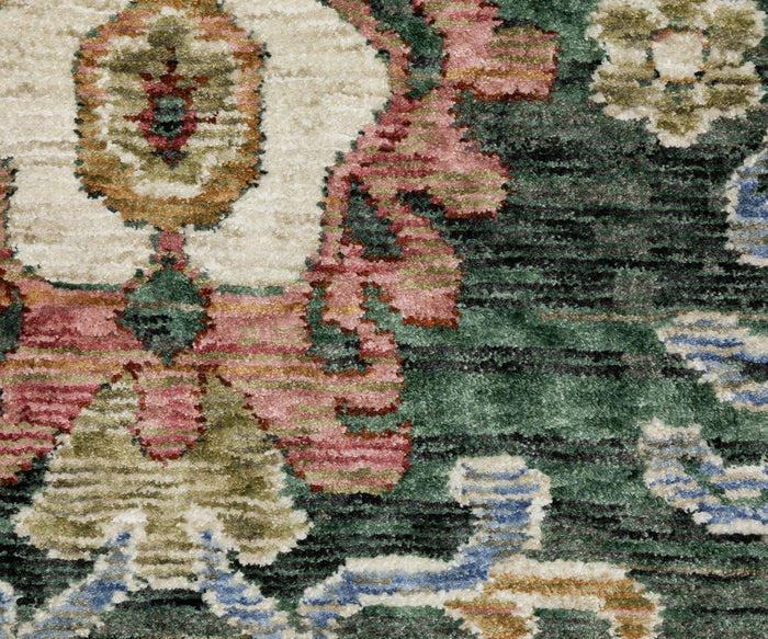 Close-up of the Oriental Weavers Hastings / HA02B Rug, highlighting its intricate floral and geometric patterns in shades of green, red, cream, blue, and brown. Crafted from space-dyed polyester fibers, the detailed texture of the rug is visible with certain areas showing a subtly raised effect.