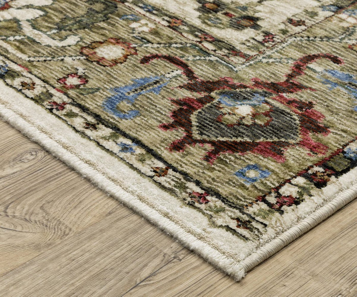 A close-up of a corner of the Oriental Weavers Hastings / HA03W Rug, a beautifully patterned multicolor area rug with floral designs in green, red, blue, and cream tones, crafted from space-dyed polyester and placed on a light wood floor.