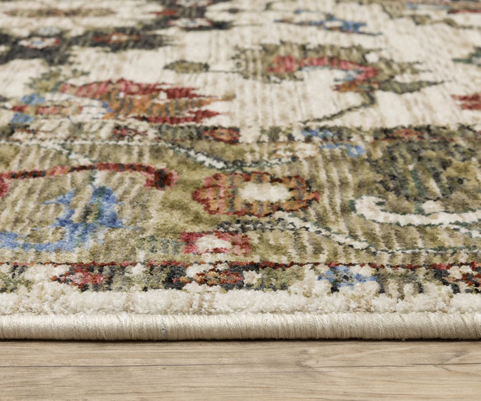 Close-up of the Oriental Weavers Hastings / HA03W Rug, a multicolor area rug featuring red, green, blue, and cream hues on a wooden floor, highlighting the space-dyed polyester construction’s texture and thickness from a side angle.