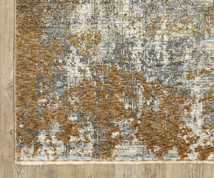 A close-up of a corner of the Oriental Weavers Hayden HAY06 Rug, which features an abstract design in brown, beige, white, and blue tones on a wooden floor. Crafted from space-dyed polyester, this rug showcases a textured, distressed appearance with a short fringe along the edge.
