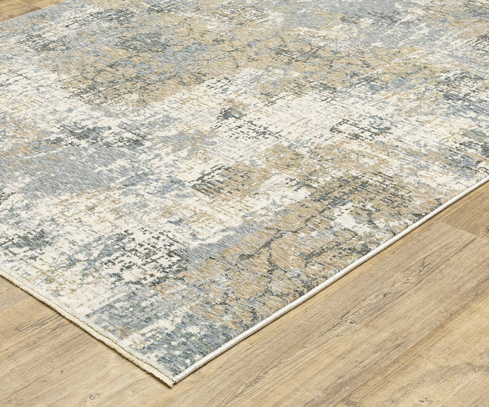The Oriental Weavers Hayden / HAY08 Rug, featuring an abstract distressed pattern in beige, gray, and blue tones, sits on a light wood floor. Crafted from space-dyed polyester for a modern look, this rectangular rug boasts clean edges and contemporary style.