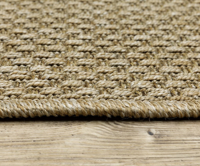 Close-up of the Oriental Weavers Karavia / 2160X Rug, a durable woven piece crafted from natural fibers with a thick border, placed on a wooden floor. The texture of the seagrass rug and the wood grain are both clearly visible.