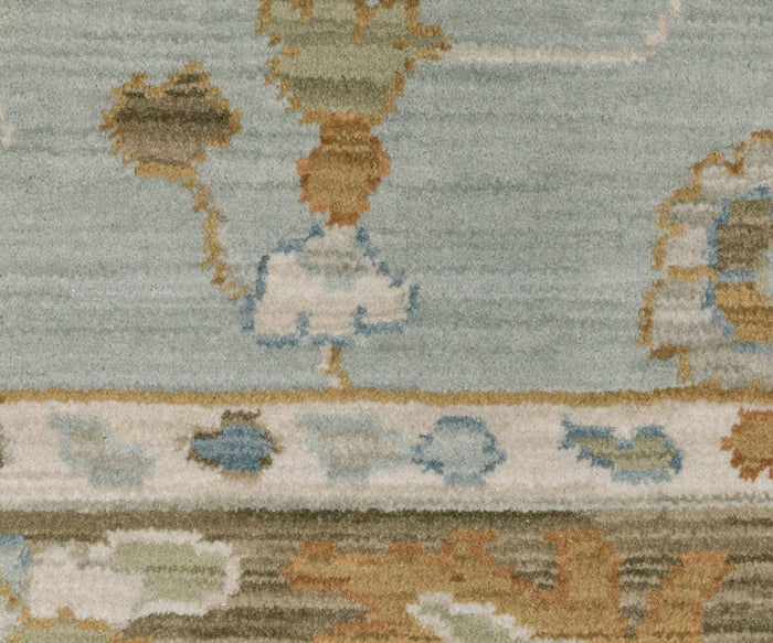 Detailed view of the Oriental Weavers Maeve / MAE06 Rug, a Persian-inspired piece showcasing abstract shapes and earthy tones like beige, blue, brown, and green. Featuring a bordered design and muted background, this boho rug is crafted from space dyed polypropylene for modern durability with timeless style.