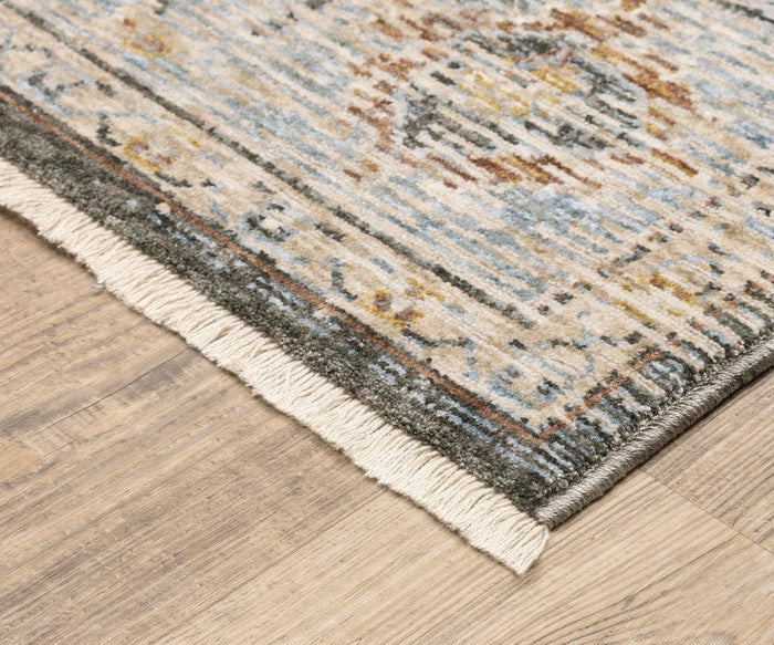 Corner of an Oriental Weavers Maharaja / 1803X Rug with fringed edge on a light wood floor. The rug features muted tones of blue, beige, yellow, and brown in a traditional design.
