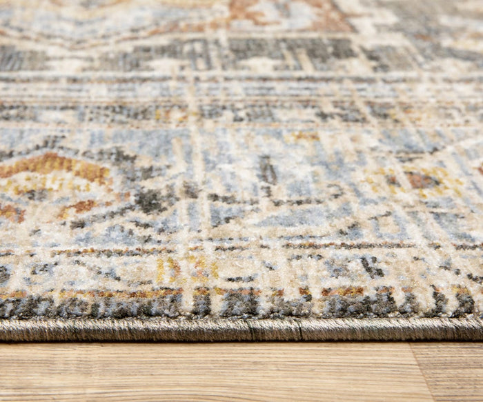 Close-up of the edge of the Oriental Weavers Maharaja / 1803X Rug, featuring Persian-inspired motifs in muted shades of beige, blue, and gold, displayed on a wooden floor.
