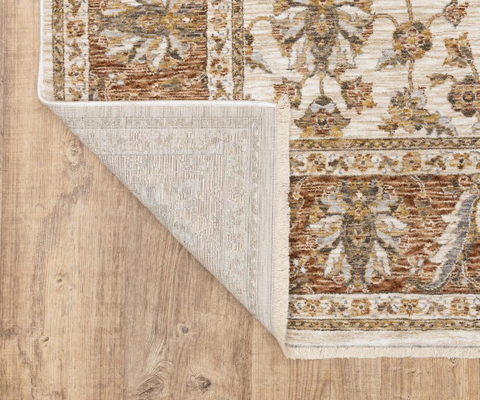 A corner of the Oriental Weavers Maharaja / 5091Q Rug from the Maharaja Collection is folded over, showing its underside. This rug features traditional floral and geometric designs in brown, beige, and gold tones on a wooden floor. Crafted from durable polyester, it promises lasting beauty and resilience.