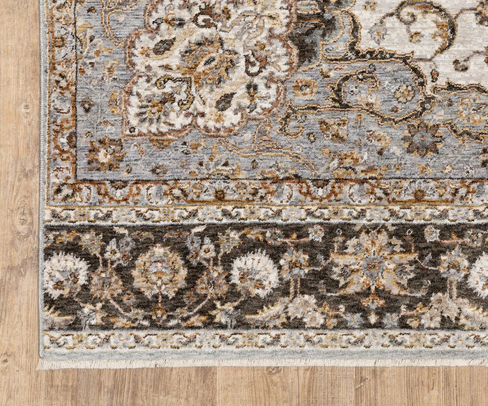 A close-up of the Oriental Weavers Maharaja / 660J Rug, a rectangular area rug from the Maharaja Collection, showcasing ornate floral and geometric motifs in gray, brown, cream, and blue tones atop a wooden floor. Crafted from durable polyester, this traditional rug offers enduring beauty and resilience.