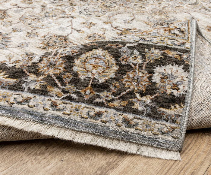 Corner of an Oriental Weavers Maharaja / 660J Rug flipped over, revealing the back and intricate floral pattern in earthy tones on a wooden floor. This durable polyester rug elegantly displays timeless traditional designs.