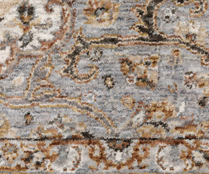 A close-up of the Oriental Weavers Maharaja / 660J Rug showcases intricate swirling traditional patterns in blue, beige, brown, and gold hues, accented by a decorative border along the bottom. Crafted from durable polyester, this rug from the Maharaja Collection offers a perfect blend of elegance and resilience.