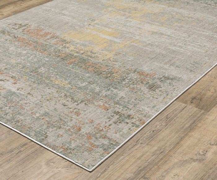 An Oriental Weavers Mallory / MAL05 Rug with a distressed pattern in muted shades of gray, yellow, blue, and orange lies on a light-colored wooden floor. Crafted from space dyed polypropylene, this earthy-toned rug brings subtle texture and warmth to any room.