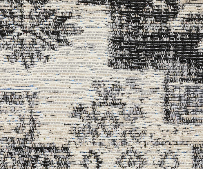 Close-up view of the Oriental Weavers Naples / 1346Z Rug, featuring a textured woven pattern in beige, gray, and black tones that evokes an abstract or floral motif. The visible threads and distinct stitching showcase the durable craftsmanship characteristic of this high-quality polypropylene rug.