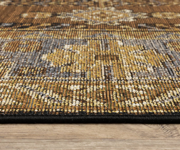 Close-up of the Oriental Weavers Naples / 1441X Rug, featuring intricate patterns in gold, brown, and gray tones on a light wood floor. The fade-resistant polypropylene material’s texture and edge are clearly visible.