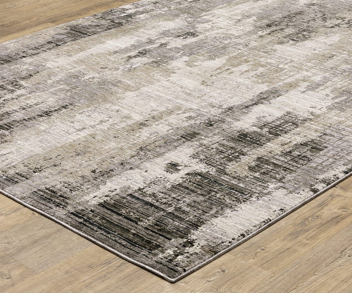 The Oriental Weavers Nebulous / 4151N Rug is a rectangular area rug, power-loomed from polyester, featuring an abstract, textured pattern in neutral shades of gray, beige, and cream. It’s shown here on a light wood floor for a modern look.
