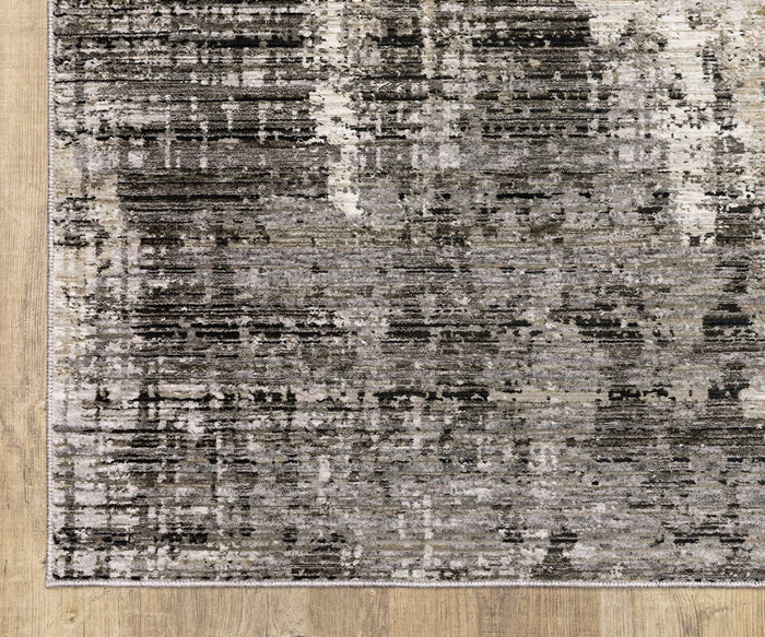 A close-up view of the Oriental Weavers Nebulous / 4151N Rug, a rectangular area rug from the Nebulous Collection, featuring a modern abstract gray, black, and white pattern crafted from power-loomed polyester and displayed on a light wood floor.