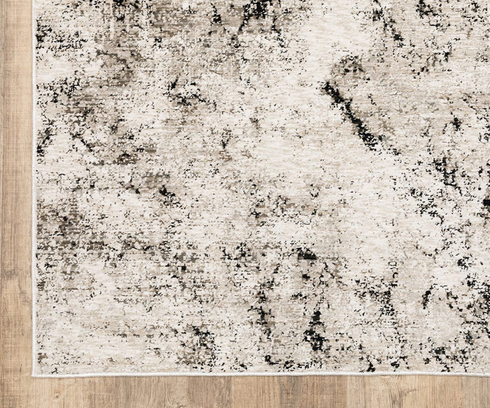 A close-up of the Oriental Weavers Nebulous / 561E Rug, showcasing its beige and gray distressed abstract pattern crafted from soft polyester yarn with space-dyed neutral tones, displayed on a light wooden floor.