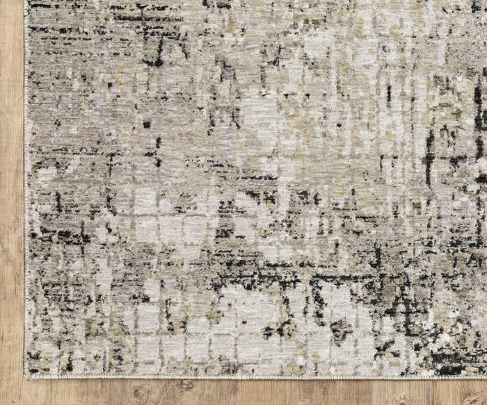 A corner of the Oriental Weavers Nebulous / 91D Rug, showcasing its abstract, distressed pattern in neutral tones, rests on a light wood floor. Crafted from soft polyester yarn, this modern rug displays shades of cream, gray, black, and subtle hints of beige.