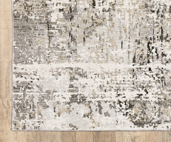 A corner of the Oriental Weavers Nebulous / 91L Rug is visible in the image, showcasing its rectangular shape and modern abstract pattern in shades of gray, white, and beige atop a wooden floor. This power-loomed polyester area rug is part of the Nebulous Collection.