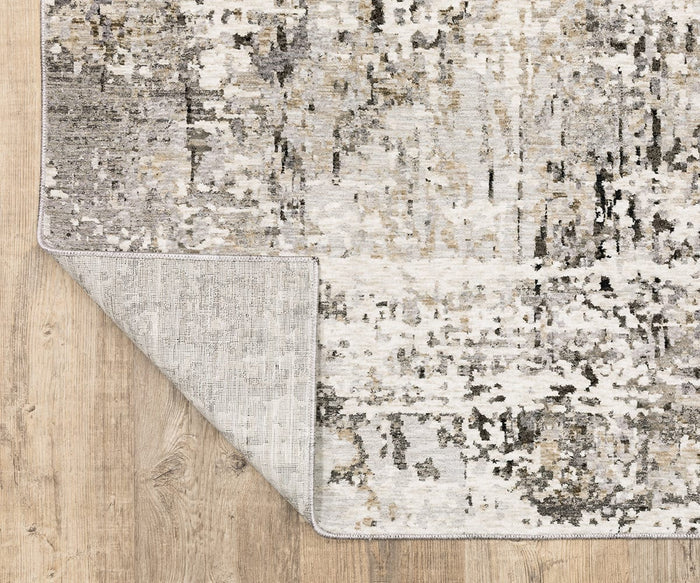 The Oriental Weavers Nebulous / 91L Rug showcases a textured, abstract pattern in neutral tones, power-loomed from polyester, and is displayed on a light wood floor with one corner folded to display the underside.