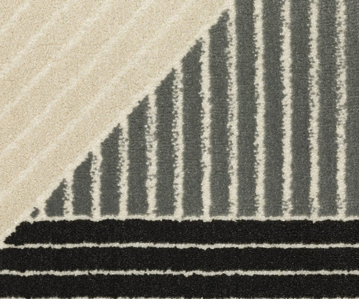 Close-up of the Oriental Weavers Raylan / RAY07 Rug, showcasing its geometric pattern with intersecting diagonal cream lines, vertical gray and white stripes, and horizontal black and white stripes. The bold design is enhanced by a high/low construction that adds rich texture to the geometric motifs.