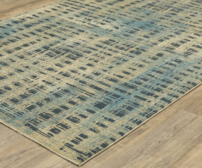The Oriental Weavers Reed / RE07B Rug is a rectangular area rug showcasing an abstract pattern in shades of blue, beige, and black on a light wood floor. Featuring a grid-like, distressed look with intersecting lines and a richly textured appearance, this rug is crafted from space-dyed polypropylene for enhanced durability and style.