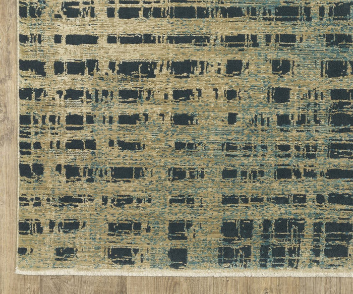 A close-up of the Oriental Weavers Reed / RE07B Rug, a rectangular, textured piece featuring a modern abstract pattern in gold and dark blue tones, crafted from space-dyed polypropylene and displayed on a wooden floor.