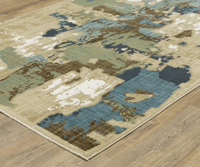 The Oriental Weavers Reed / RE11Q Rug, showcased on a wood floor, displays modern abstract design with blue, brown, green, and cream hues. Its irregular overlapping shapes and distressed appearance are crafted from durable space-dyed polypropylene for long-lasting style.