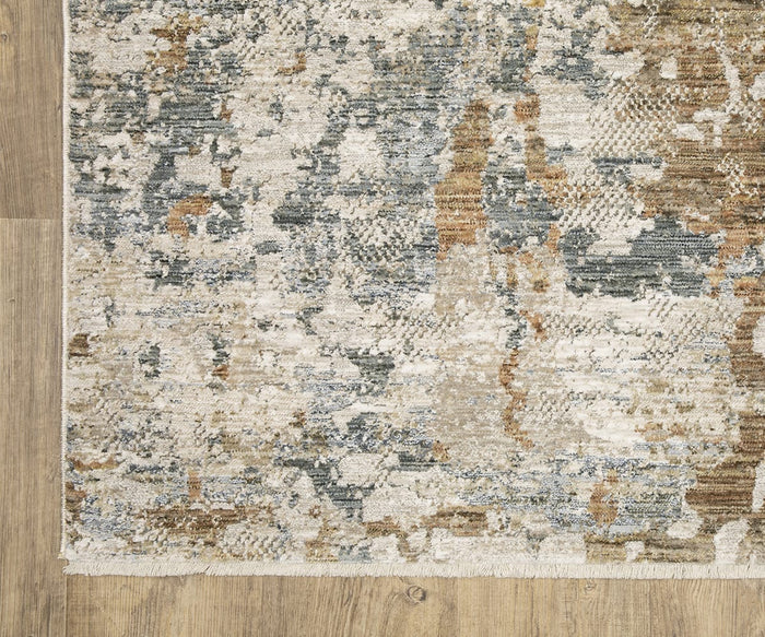 A corner of the Oriental Weavers Soho / SOH08 Rug showcases its mix of beige, gray, blue, and brown abstract patterns—artfully crafted from space-dyed polyester yarns—resting on a light wood floor. This elegant rug from the Soho Collection features a fringed edge for added sophistication.