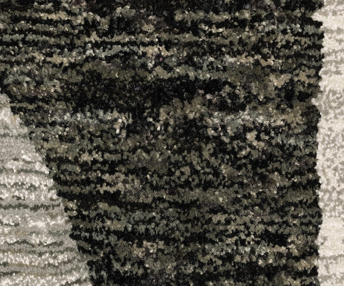 Close-up of the Oriental Weavers Strada / STR06 Rug, featuring a textured surface with an artful mix of dark brown, black, gray, and beige fibers in a mottled abstract pattern. This machine-woven nylon Art Deco rug is perfect for introducing sophistication to modern spaces.