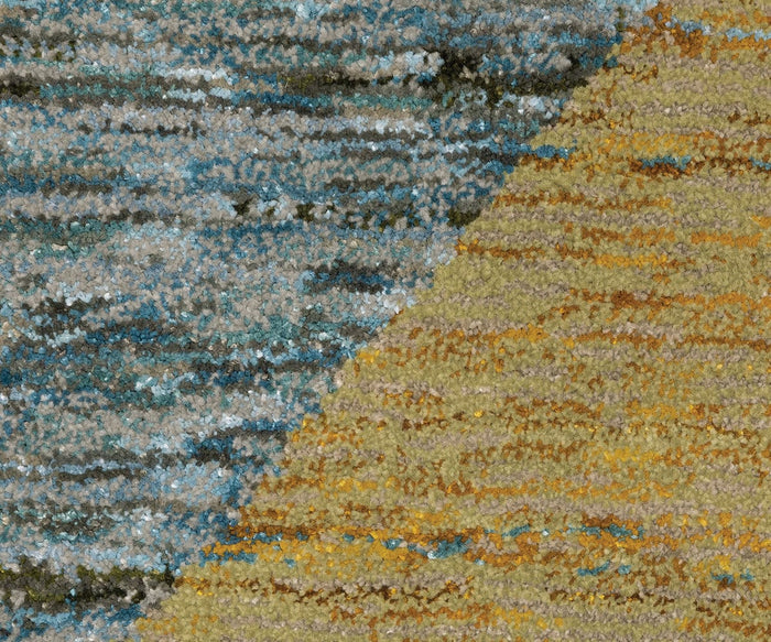 Close-up of the Oriental Weavers Strada / STR09 Rug, highlighting its modern textured carpet detailing and bold diagonal division; one side displays blue and gray hues, while the other features yellow, gold, and light brown shades for a striking, contrasting pattern.