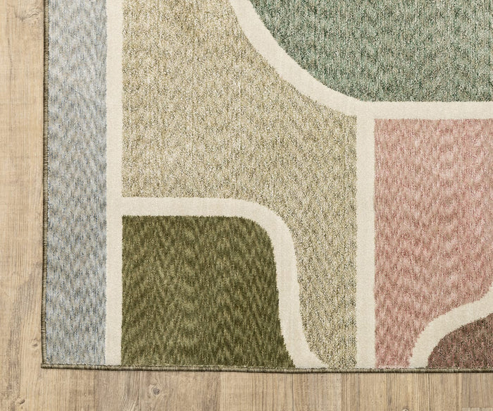 The Oriental Weavers Tisdell / TIS02 Rug features abstract curved, geometric shapes in green, beige, pink, and blue tones outlined by cream-colored lines on a wooden floor. Crafted from space-dyed polyester for added depth and durability, this modern rug is designed to withstand everyday wear while elevating your décor.