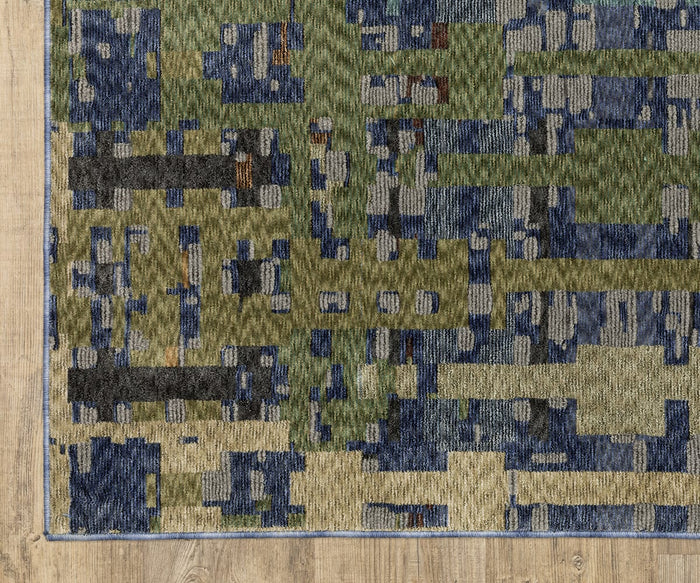 A close-up of the Oriental Weavers Tisdell / TIS03 Rug, a modern rectangular area rug crafted from space-dyed polyester, showcases an abstract pattern in shades of green, blue, and beige on a light wood floor. This durable rug beautifully blends contemporary style with lasting quality.