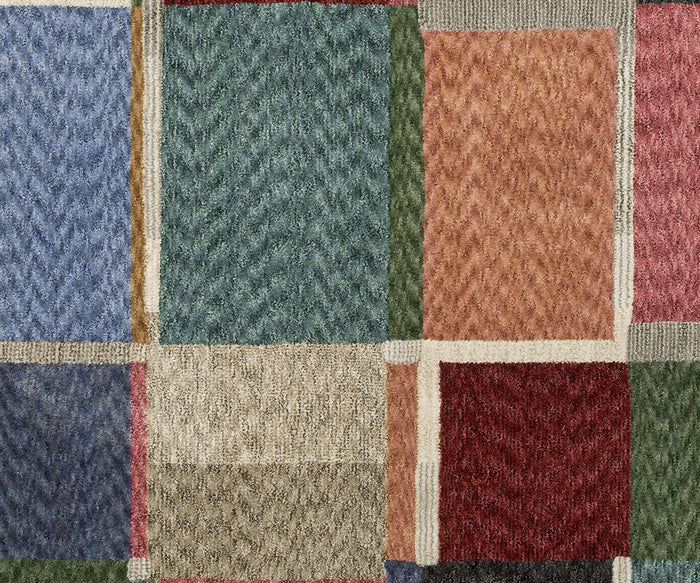 A close-up of the Oriental Weavers Tisdell / TIS05 Rug highlights its soft, woven texture and patchwork pattern of rectangles in green, red, blue, beige, pink, and brown—crafted from durable space-dyed polyester for a modern abstract look.