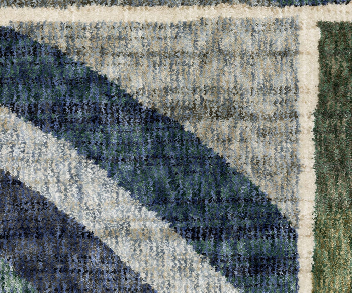 Close-up of the Oriental Weavers Tisdell / TIS06 Rug, showcasing its textured, space-dyed polyester surface with curved, intersecting shapes in navy blue, gray, green, and cream tones that form a modern abstract geometric pattern.