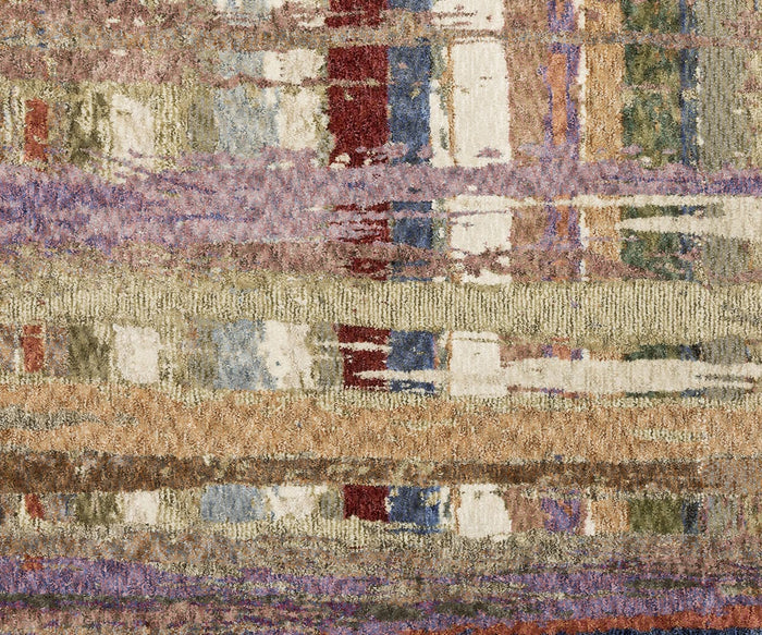A close-up of the Oriental Weavers Tisdell / TIS08 Rug showcases its multicolored, woven texture with horizontal bands of purple, brown, beige, red, blue, and green. The abstract pattern blends muted and vibrant shades for a striking modern look—crafted from space-dyed polyester to create a durable area rug that stands out in any room.