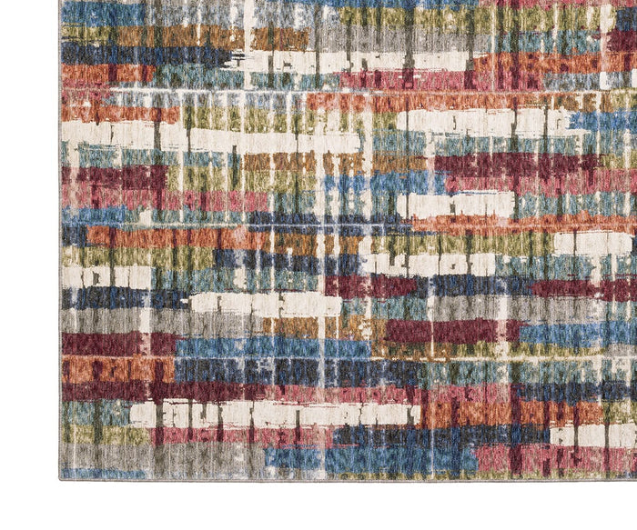 A close-up of the Oriental Weavers Tisdell / TIS12 Rug showcases its durable corner and abstract pattern in red, blue, yellow, green, gray, and white, featuring horizontal lines and rectangular shapes.