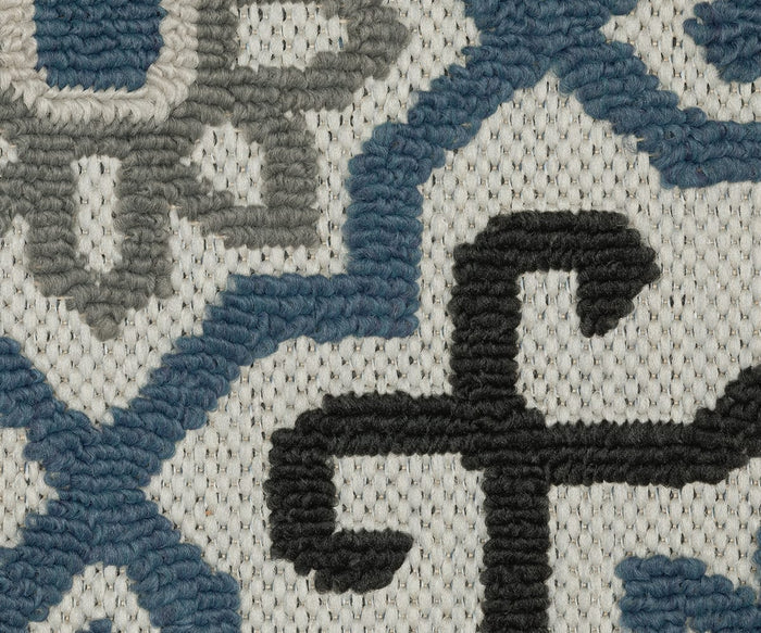 Close-up of the Oriental Weavers Torrey / 004Y Rug showcases its textured fabric with blue, black, and gray embroidered geometric and floral patterns on a cream background. The detailed stitching and yarnwork add dimension to the neutral tones and highlight the abstract motifs woven throughout the design.